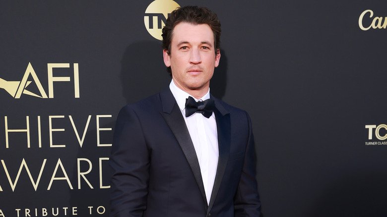 Miles Teller in suit posing