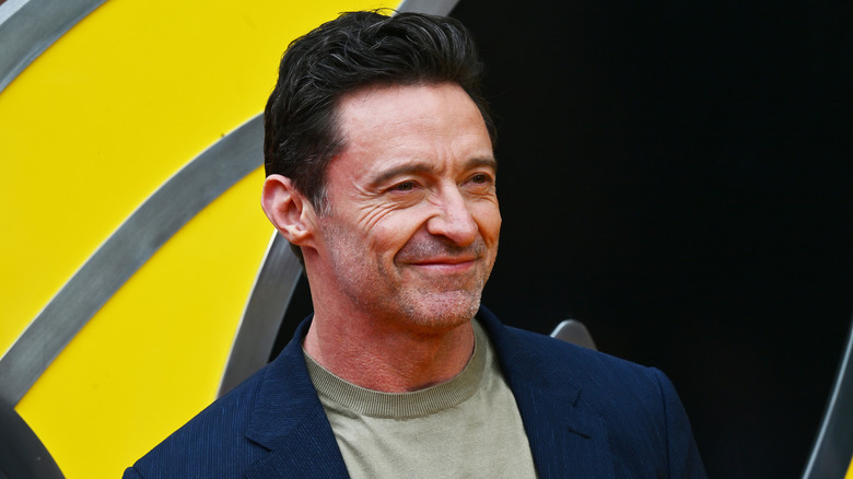 Hugh Jackman smiling wearing jacket