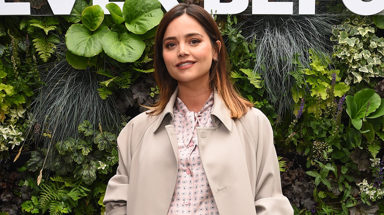 Jenna Coleman near plant wall