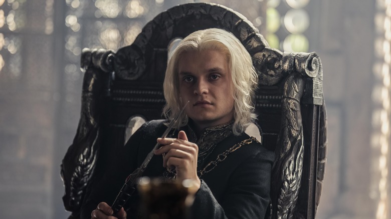 Aegon holding knife on throne